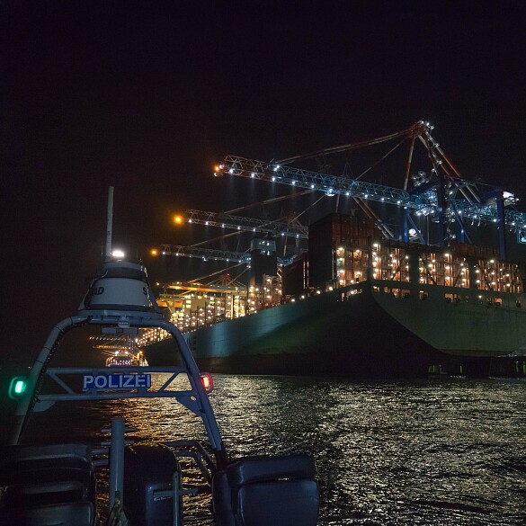 Hier sehen Sie ein Polizeiboot bei einem Einsatz an der Stromkaje in Bremerhaven bei Nacht