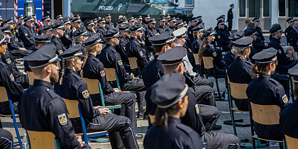 Auf dem Foto sind mehrere Polizisten auf Stühlen zu sehen 