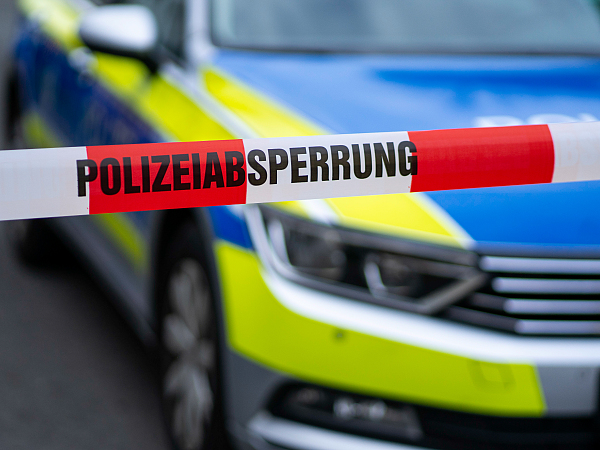 Polizeiliches Absperrband vor einem Streifenwagen