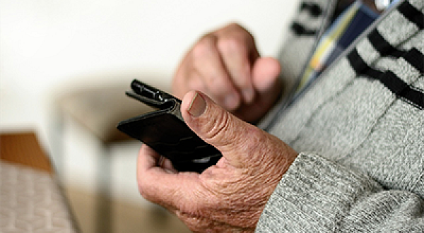 Älterer Mann mit einem Mobiltelefon in der Hand 