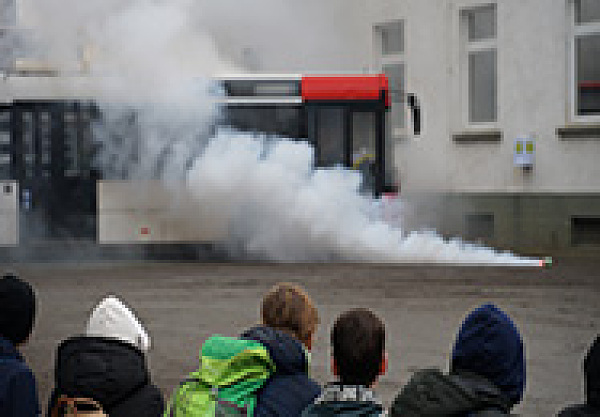 Auf dem Bild sind Kinder von hinten beim Kids Day der Polizei Bremen zu sehen. Im Hintergrund sieht man Rauch vor einem Bus.